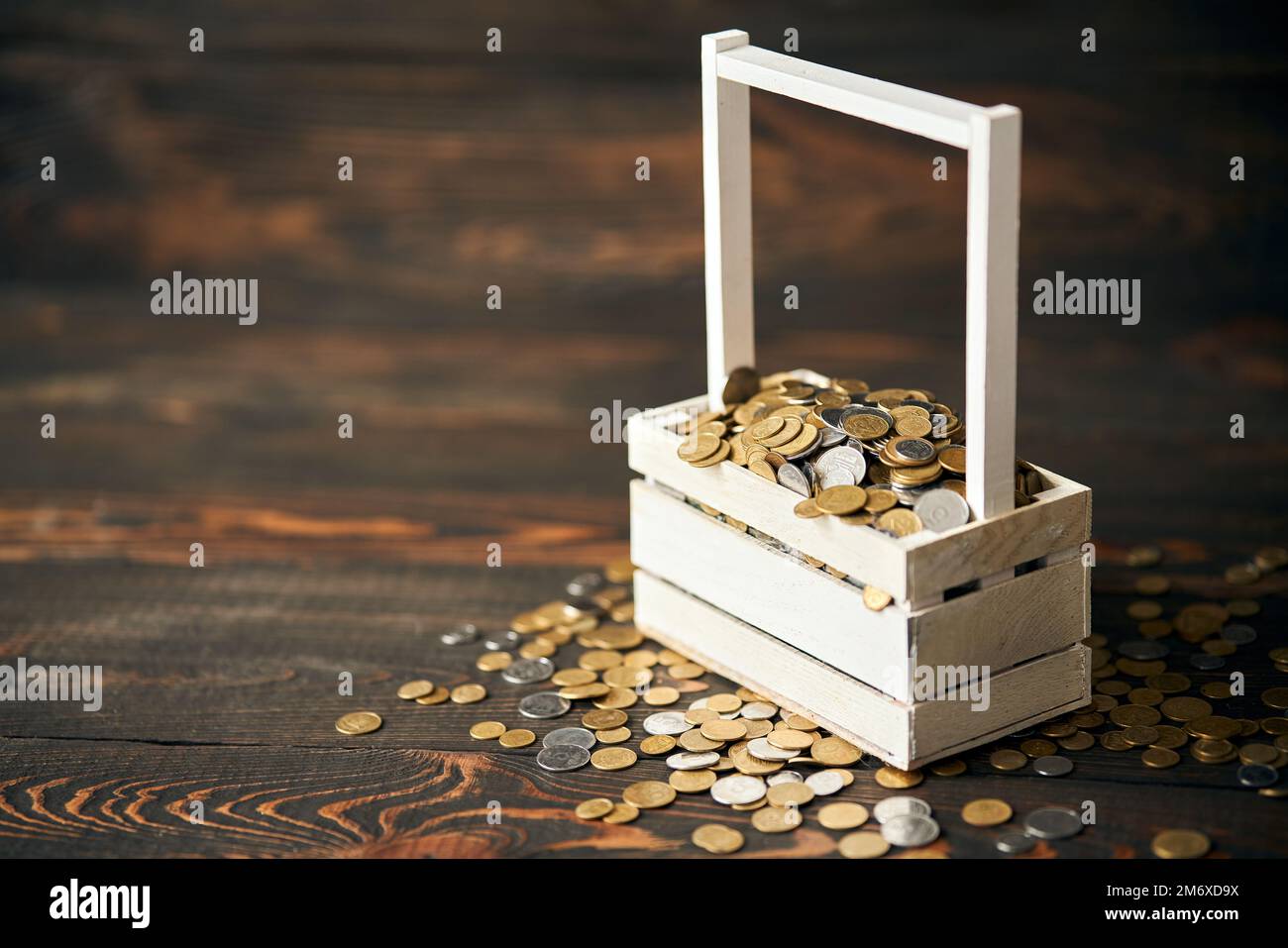 Panier rempli de pile de pièces avec espace pour le texte sur fond en bois Banque D'Images