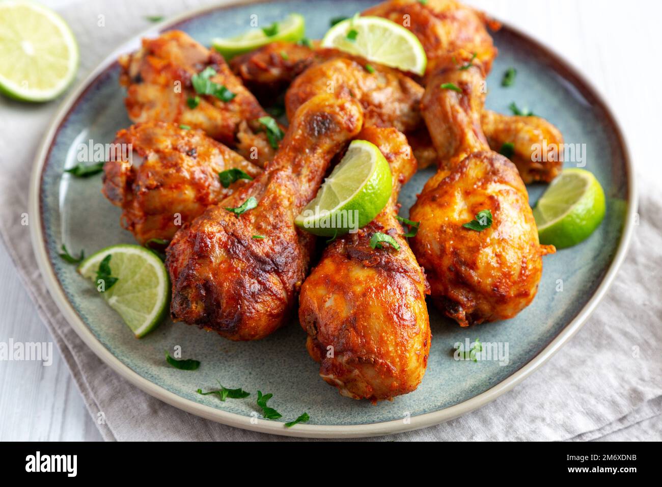 Poulet jerk grillé maison avec citron vert sur une assiette, vue latérale. Gros plan. Banque D'Images