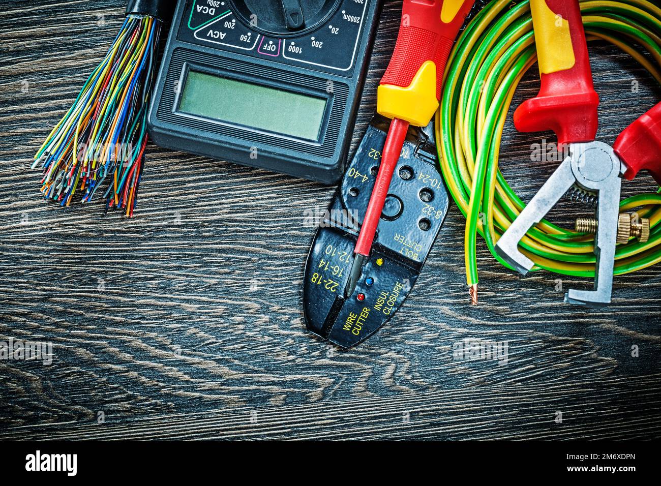 Tournevis pour testeur de fils électriques, pinces à dénuder pour câble roulé sur panneau en bois. Banque D'Images