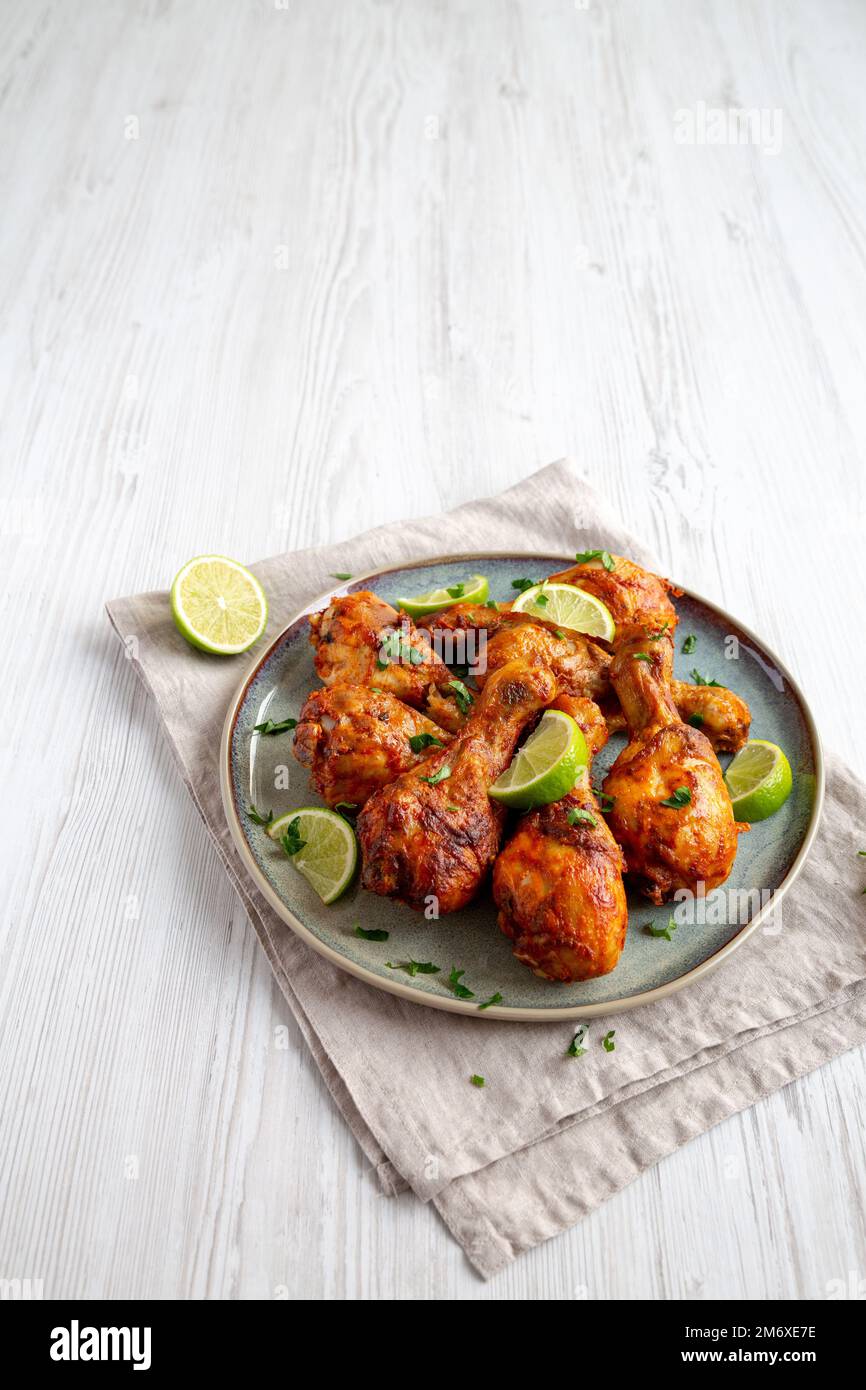 Poulet jerk grillé maison avec citron vert sur une assiette, vue latérale. Espace pour le texte. Banque D'Images