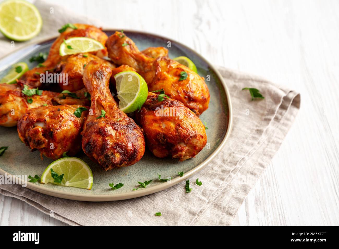 Poulet jerk grillé maison avec citron vert sur une assiette, vue latérale. Espace pour le texte. Banque D'Images