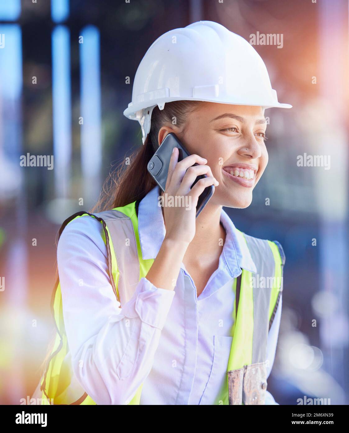 Travailleur de la construction, femme avec smartphone pour les appels téléphoniques et la communication avec la technologie et casque pour la sécurité. Heureux de la construction, de la construction Banque D'Images