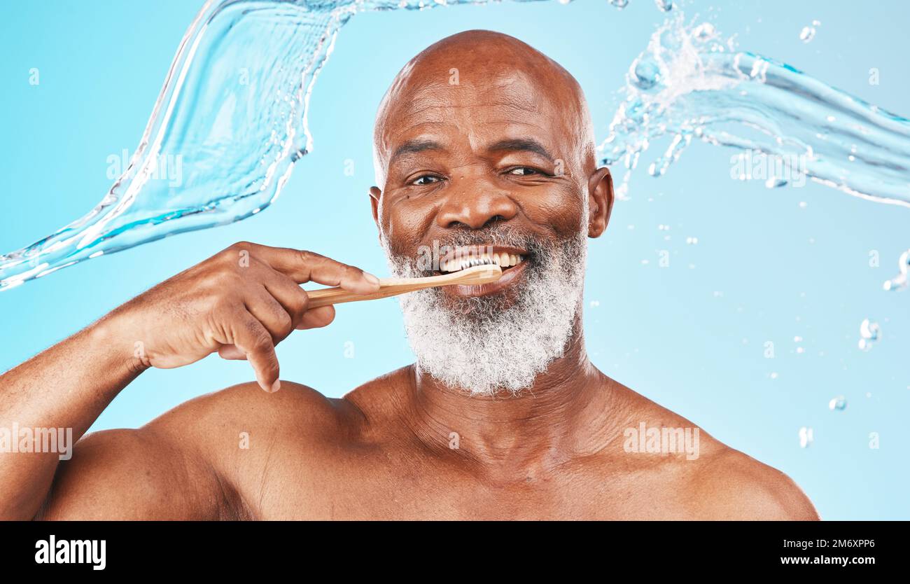 Homme noir, hygiène dentaire et brosse à dents avec eau, bien-être et hygiène sur fond bleu studio. Santé bucco-dentaire, Afro-américain et Banque D'Images