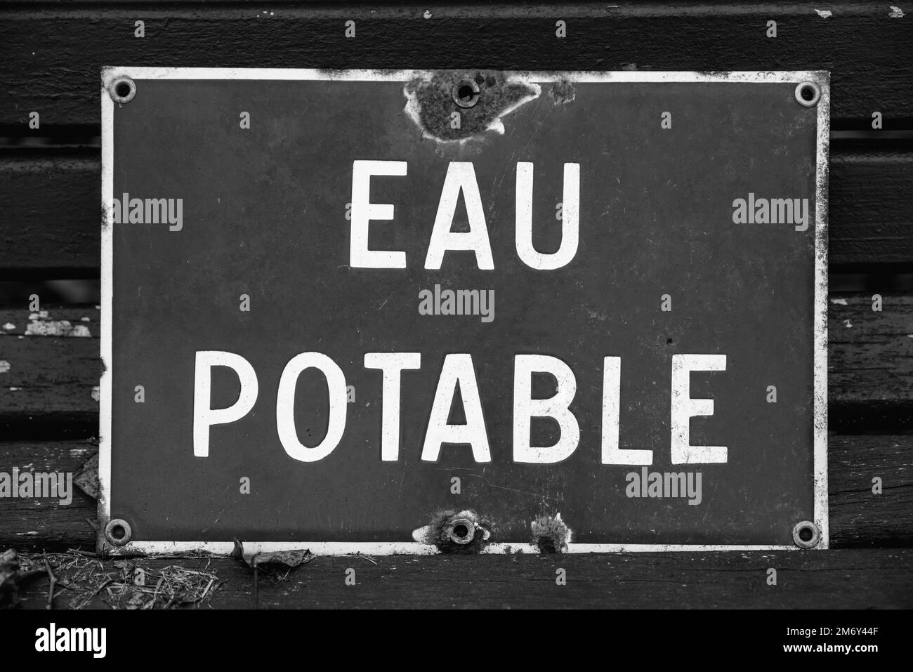 Eau potable en français. Panneau de route eau potable. Panneau d'eau potable endommagé. Gros plan sur un panneau endommagé eau potable. Banque D'Images