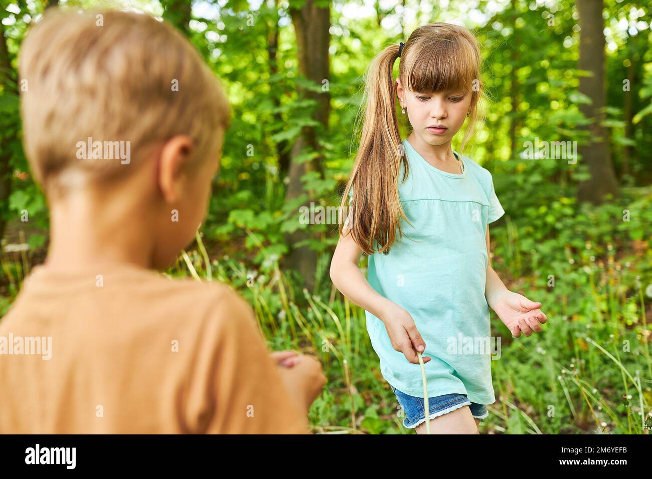 Fille blonde randonnée dans la forêt avec frère tout en faisant la découverte pendant les vacances Banque D'Images