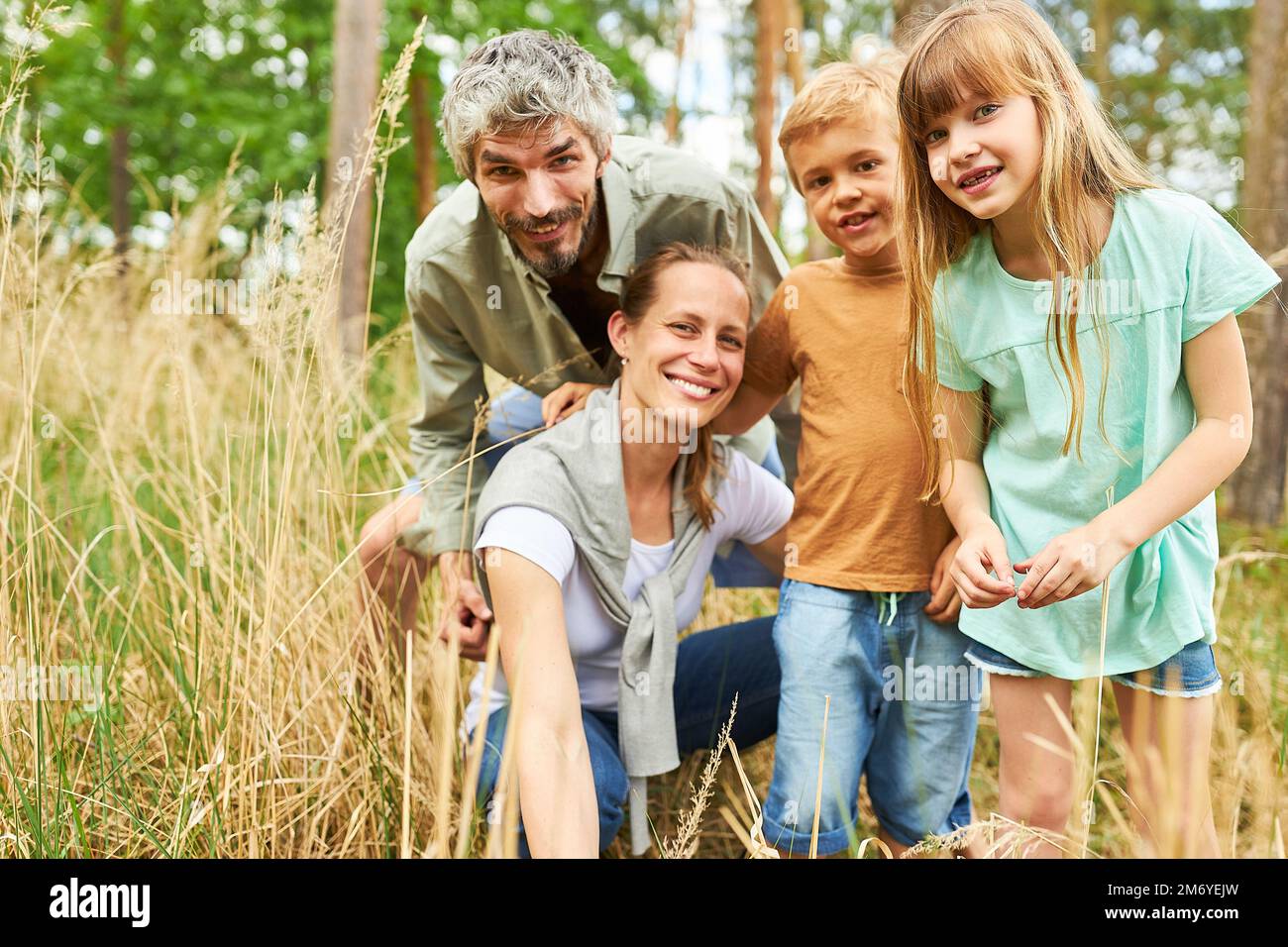 Portrait des enfants heureux et des parents explorant la forêt ensemble en vacances d'été Banque D'Images