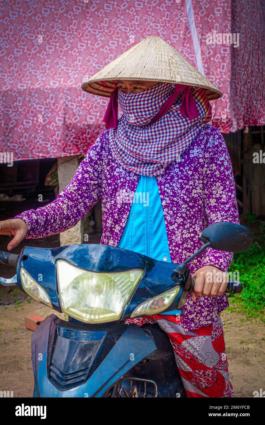 Visages du monde: Femme vietnamienne à moto Banque D'Images