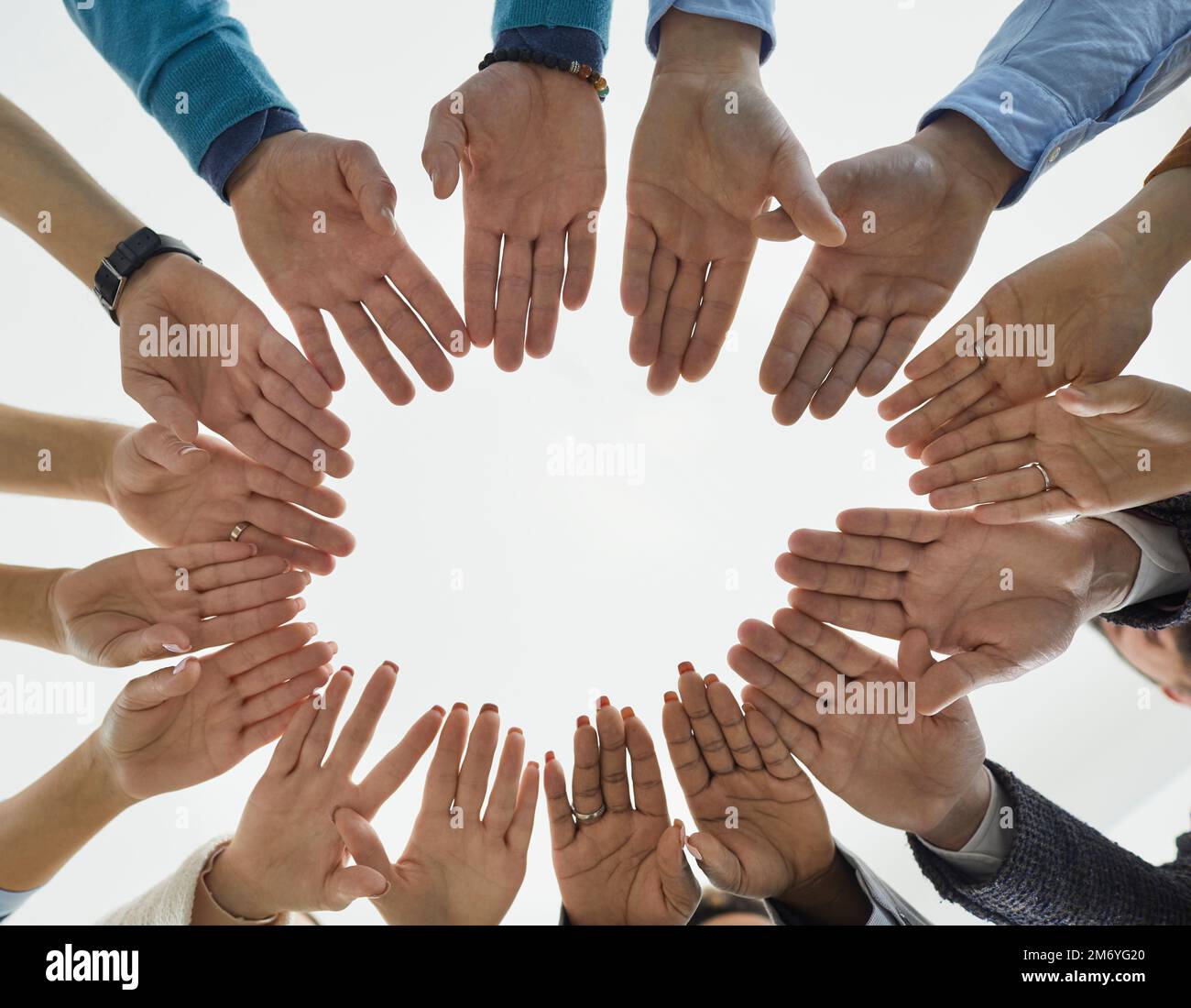 Des personnes diverses forment un cercle de mains démontrant l'égalité, l'unité et la solidarité. Banque D'Images