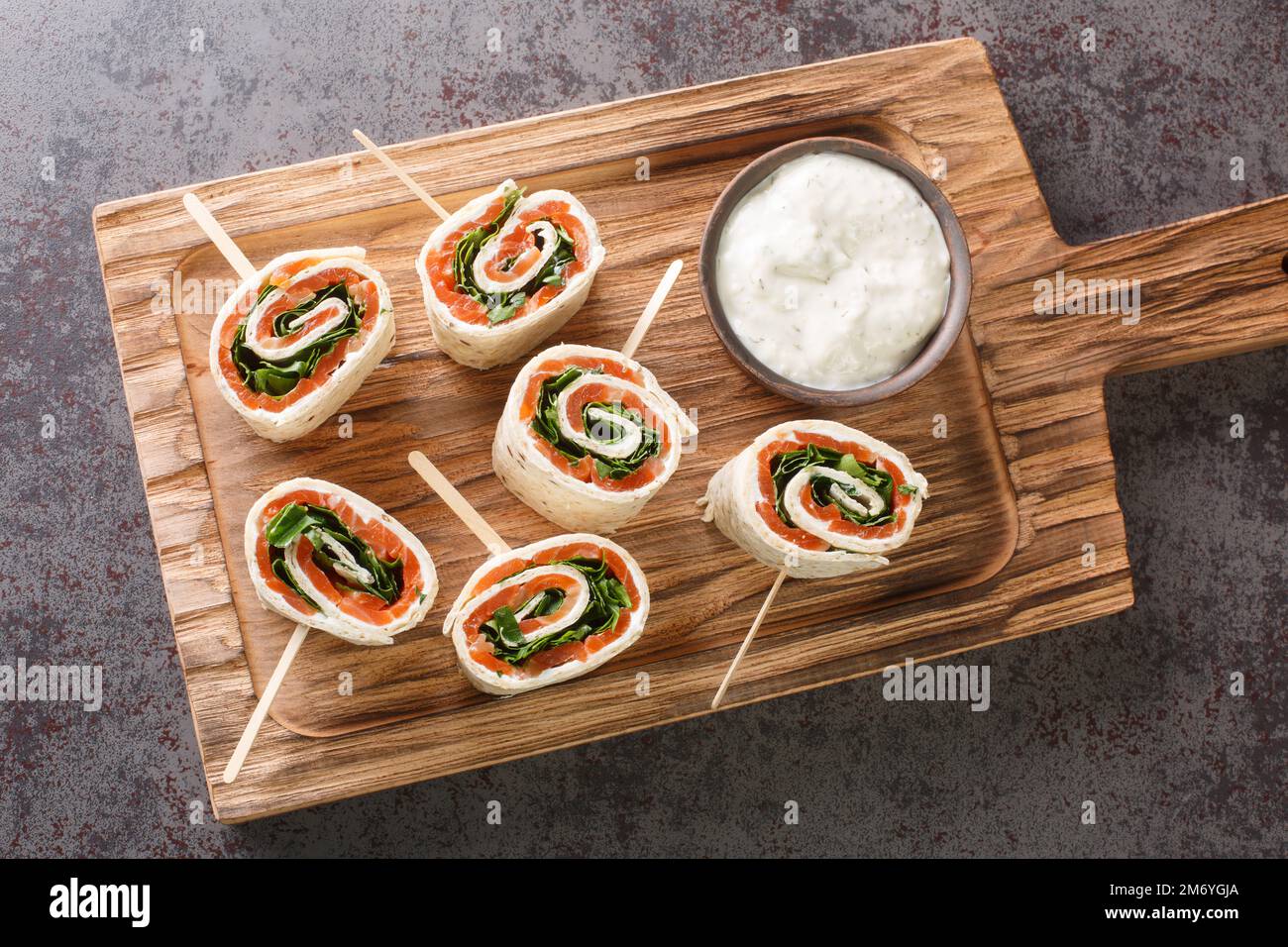 De savoureux petits pains avec du saumon, du fromage et des légumes pour un brunch en gros plan sur le plateau de la table. Vue horizontale du dessus Banque D'Images