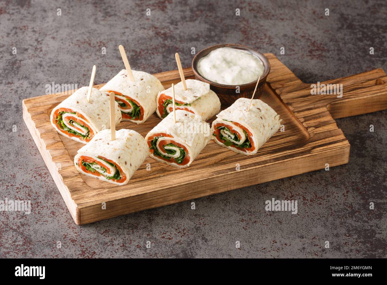 De savoureux petits pains avec du saumon, du fromage et des légumes pour un brunch en gros plan sur le plateau de la table. Horizontale Banque D'Images