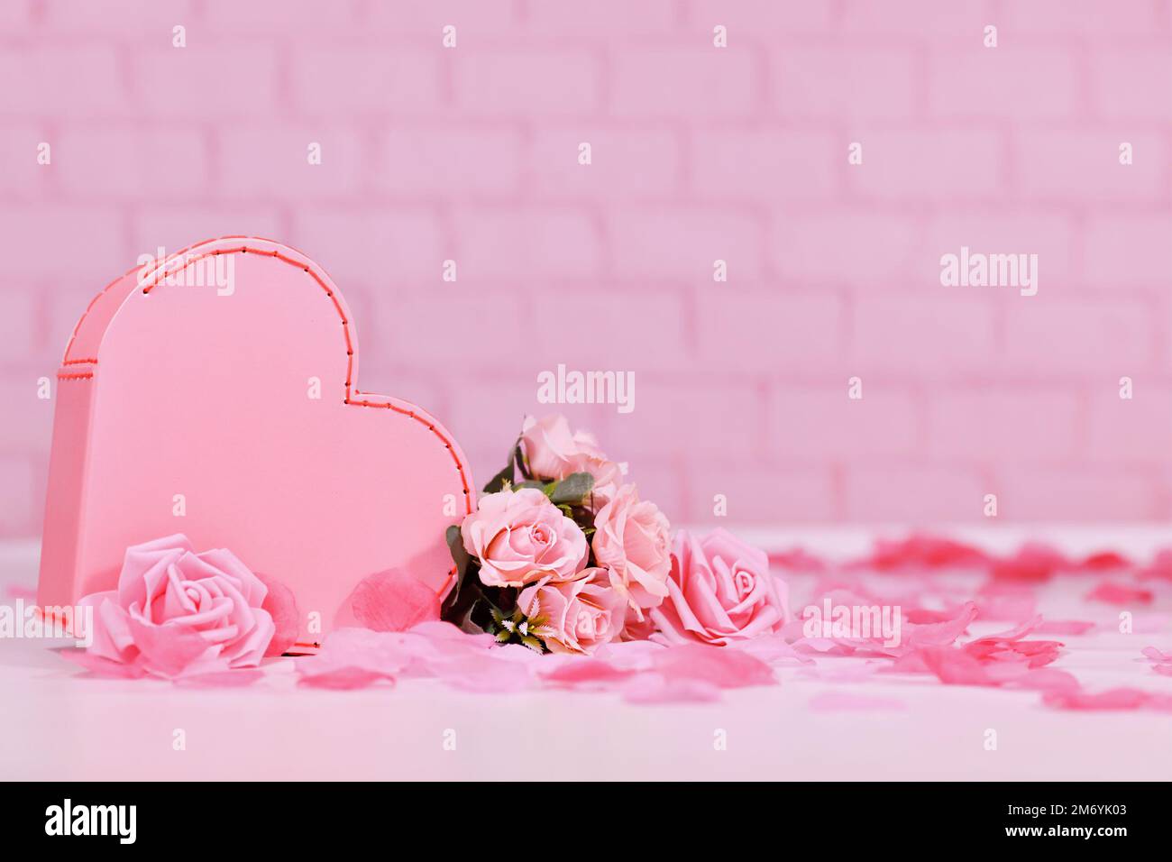 Composition de la Saint-Valentin avec boîte en forme de coeur et fleurs roses sur fond rose avec espace de copie Banque D'Images