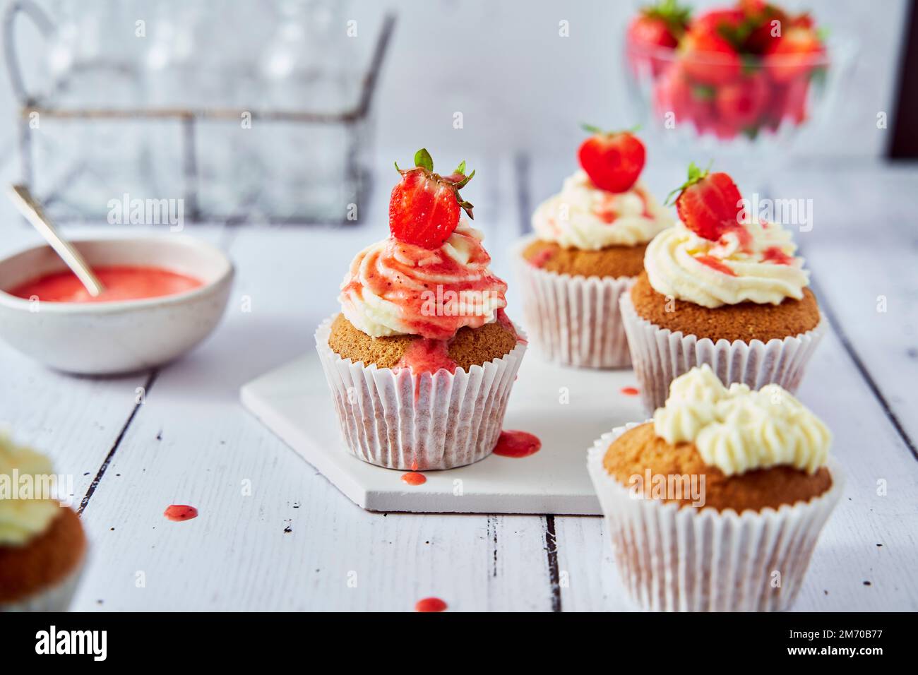 Cupcakes aux fraises avec glaçage au fromage à la crème et coulis Banque D'Images