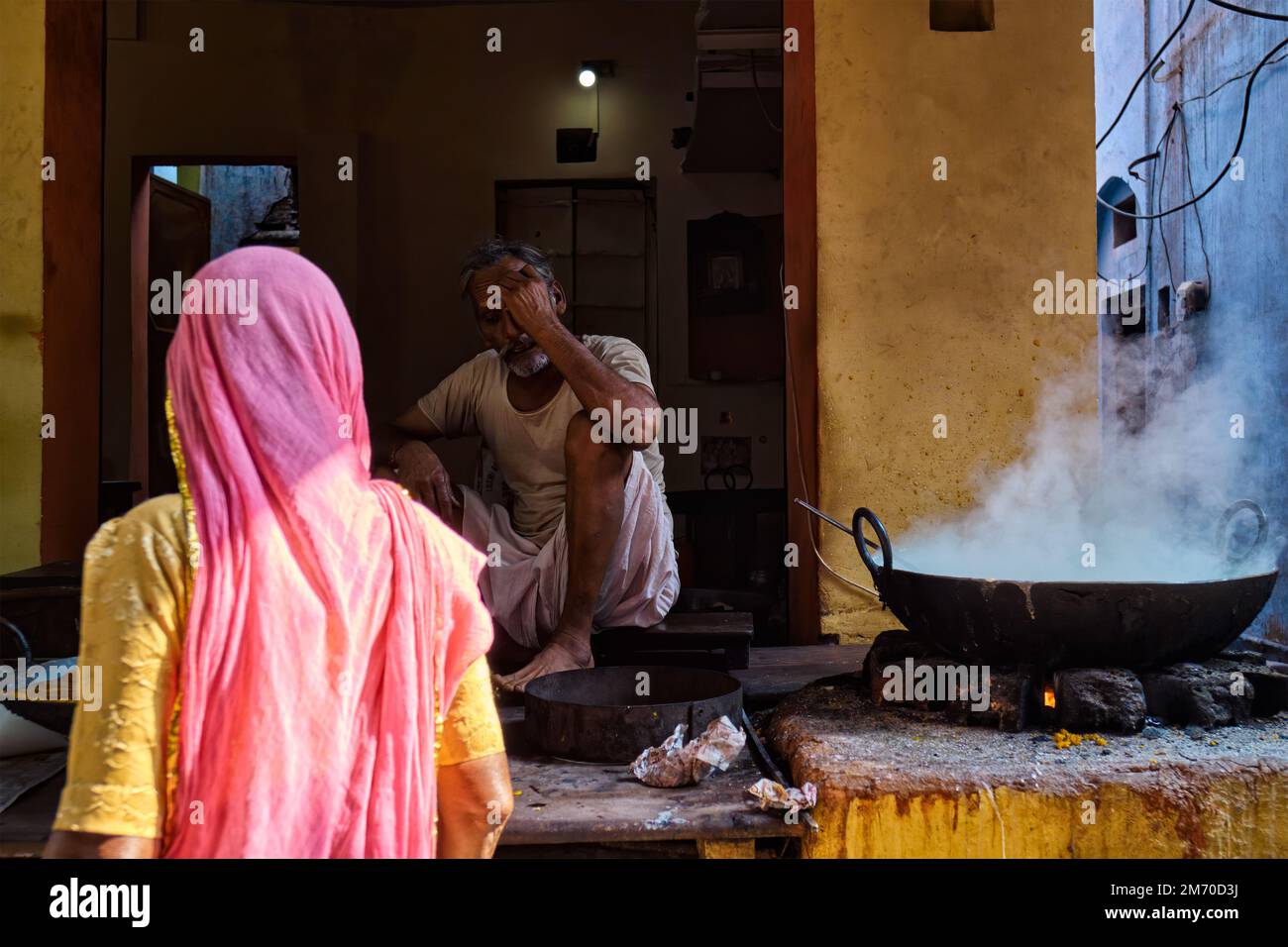Pushkar, Inde - 7 novembre 2019: Femme achetant à partir de la rue nourriture stall cuisiner pain puri doux et rabri doux, condensé-lait-à base de plat Banque D'Images