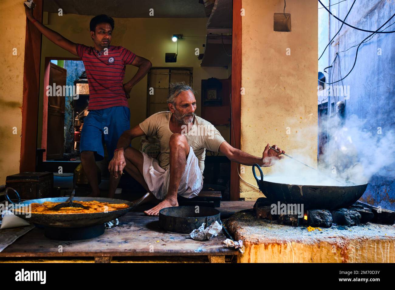 Pushkar, Inde - 7 novembre 2019: Cuisine de rue stalle cuire le mélange avec la cuillère pain doux puri et rabri doux, condensé-lait-à base de plat dans str Banque D'Images