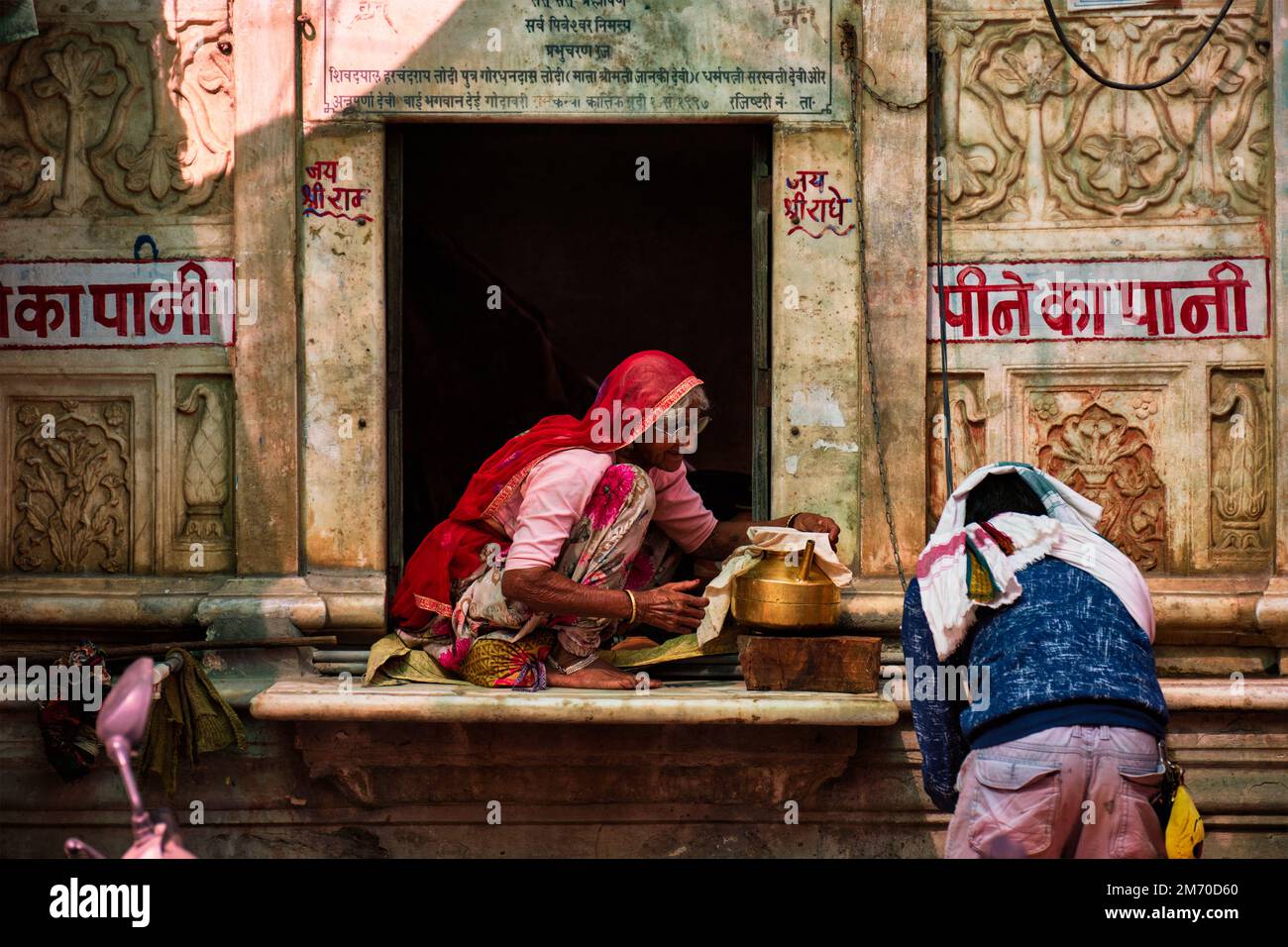 Femme fournissant de l'eau potable dans la rue de Pushkar, Rajasthan, Inde Banque D'Images