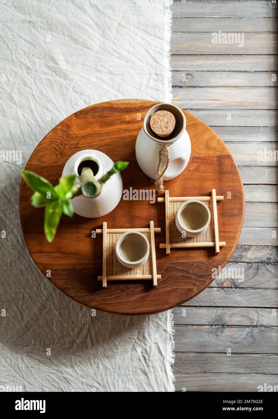 Le saké japonais est encore vivant avec une branche de bambou, un fond de lin léger, une cérémonie asiatique Banque D'Images