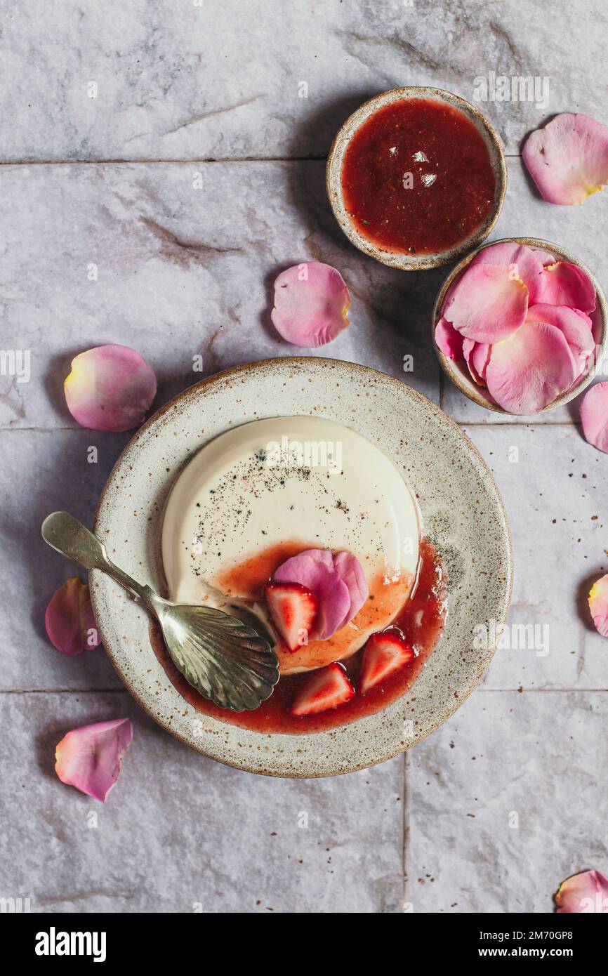 Pañas cotta à la rose Flatlay avec compote de fraises et cuillère Banque D'Images