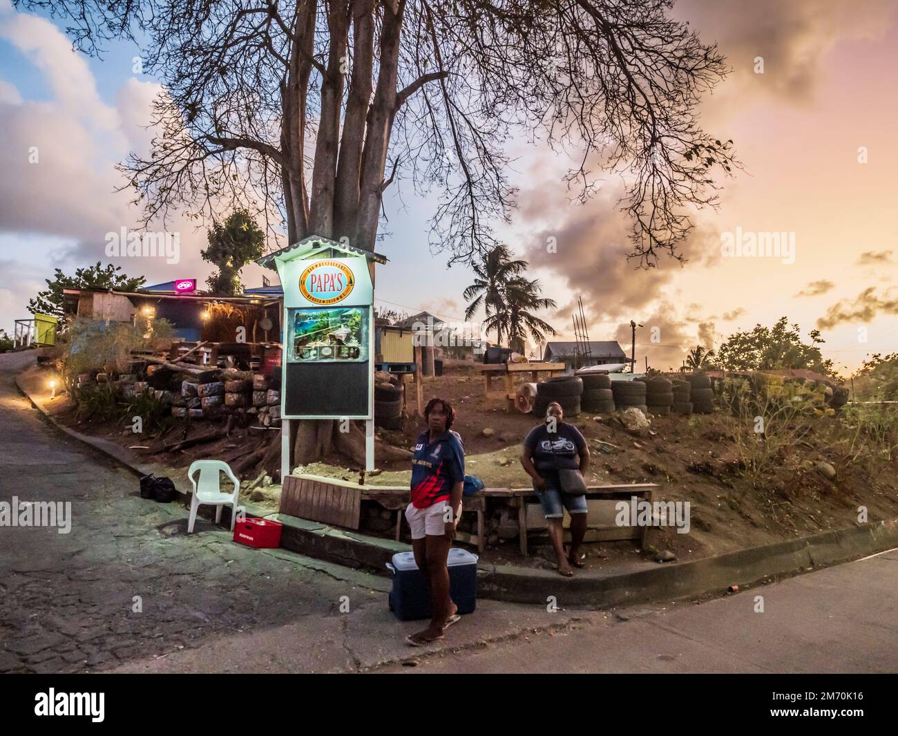 Bequia, Grenadines Caraïbes île. Scène en bord de route par la boîte de nuit du soir nesr Papas. Banque D'Images