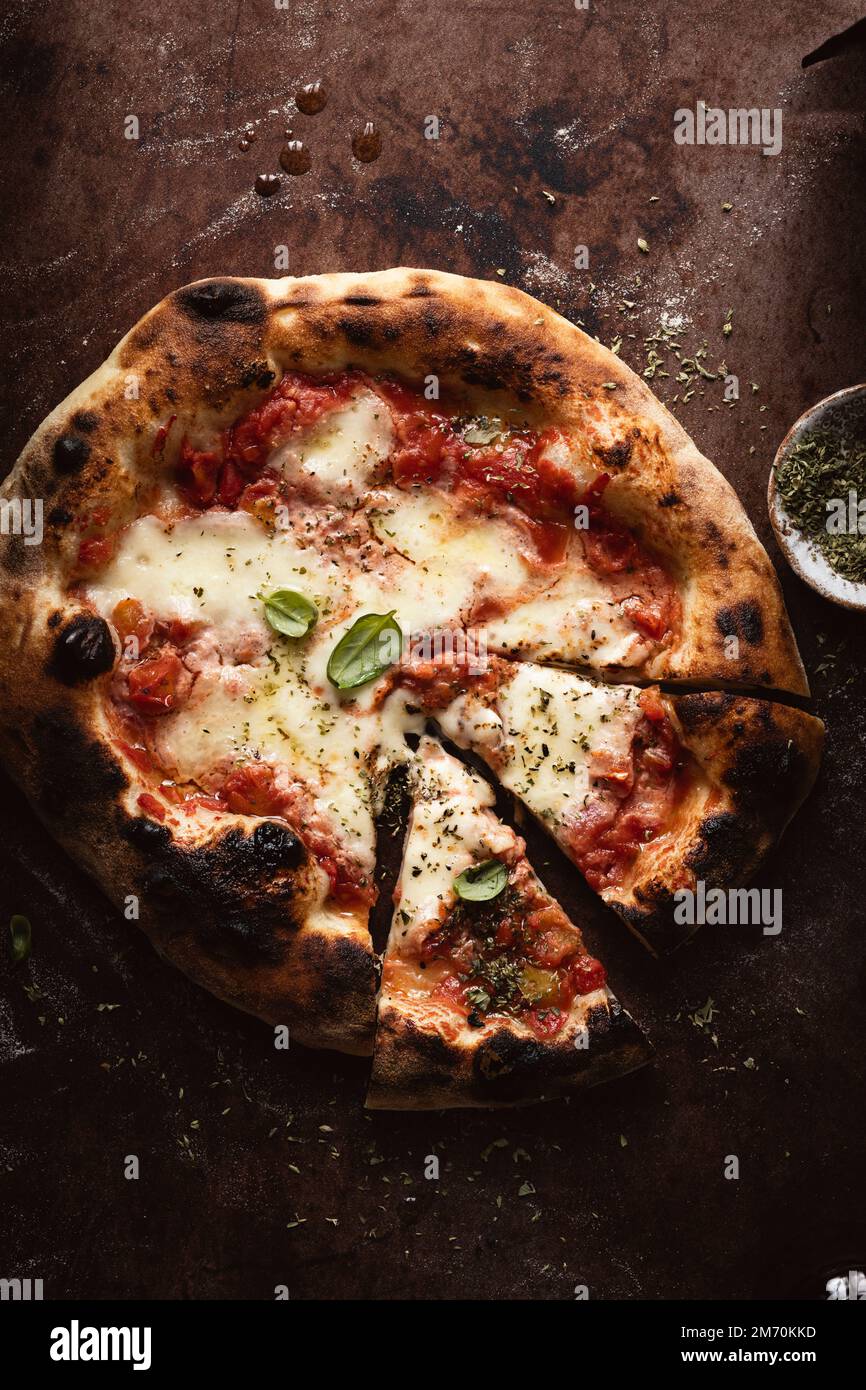 pizza maison en tranches margherita sur une surface sombre Banque D'Images