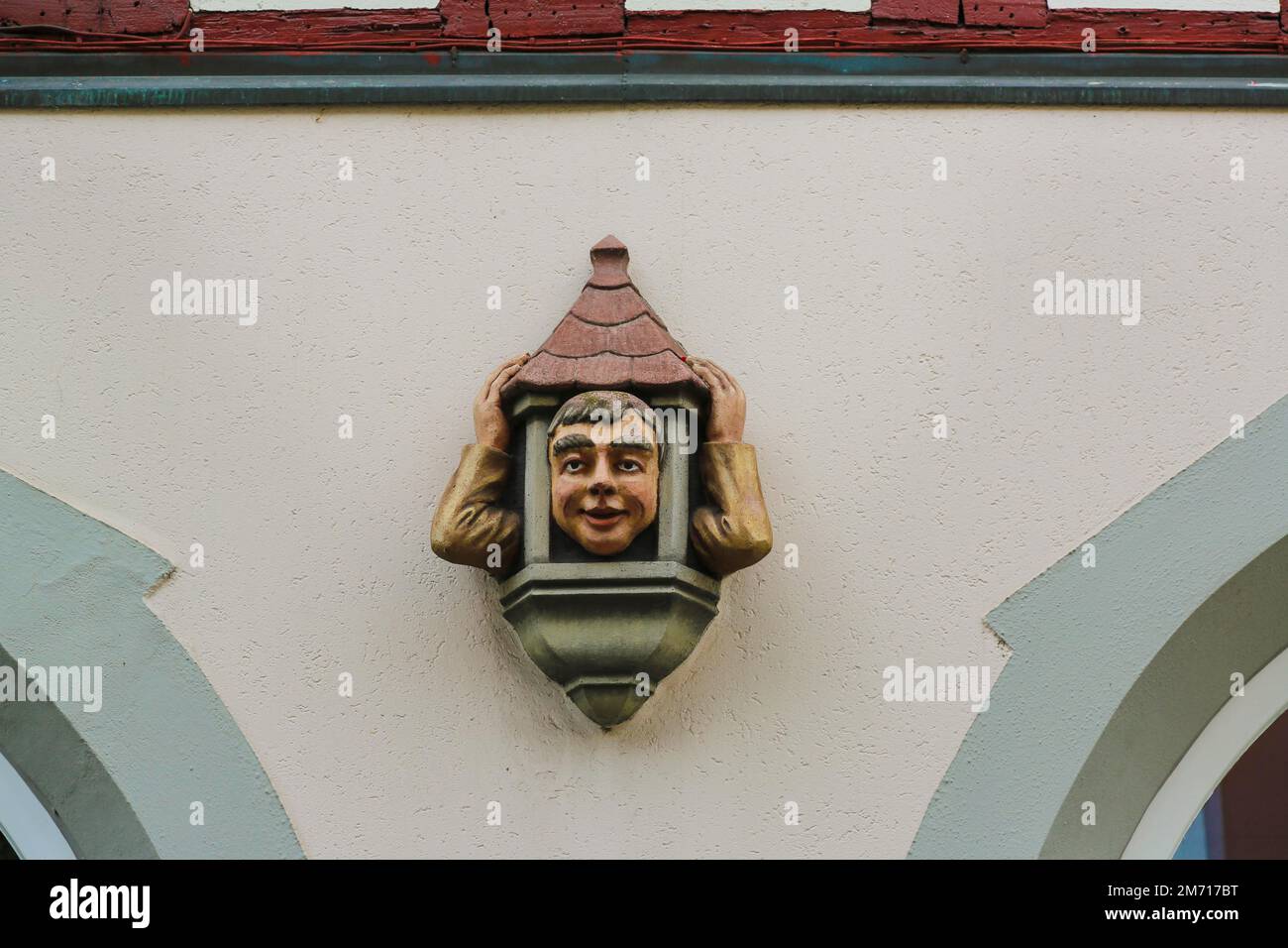 Figure, tête d'homme drôle et bras avec toit de maison, décoration sur le bâtiment, façade, décoration murale, Ueberlingen am Lac de Constance Banque D'Images