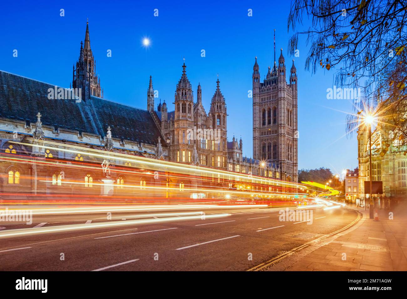 Les voitures passent à côté du palais de Westminster à Londres, Angleterre, Royaume-Uni, au crépuscule Banque D'Images