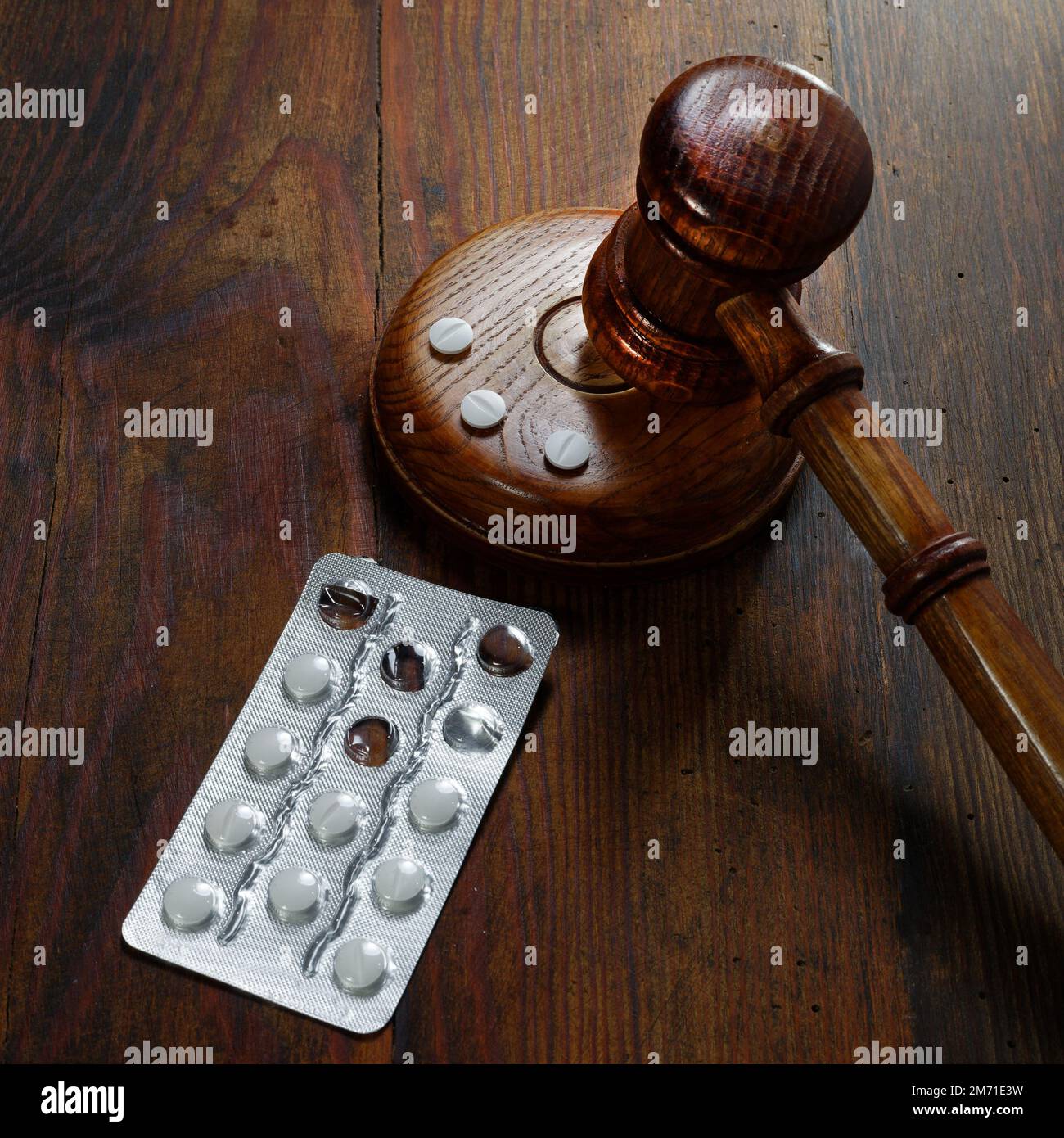 Droit en médecine. Jugez le gavel et les pilules sur un fond en bois. Concept de droit médical et de crimes médicaux Banque D'Images