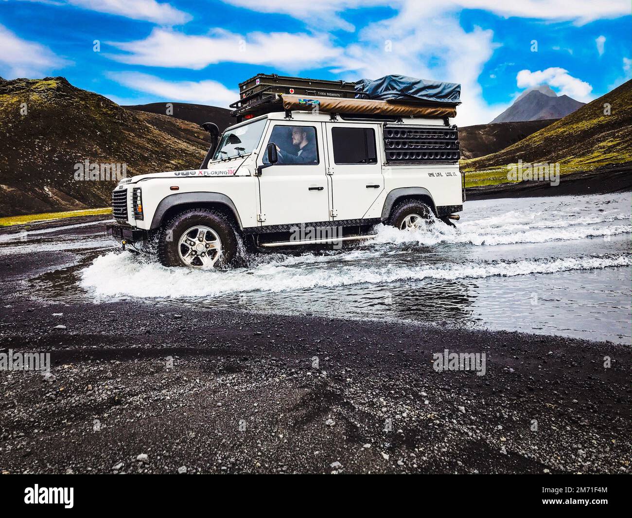 Un Land Rover Defender 110 blanc traversant dans les eaux des hauts plateaux Banque D'Images