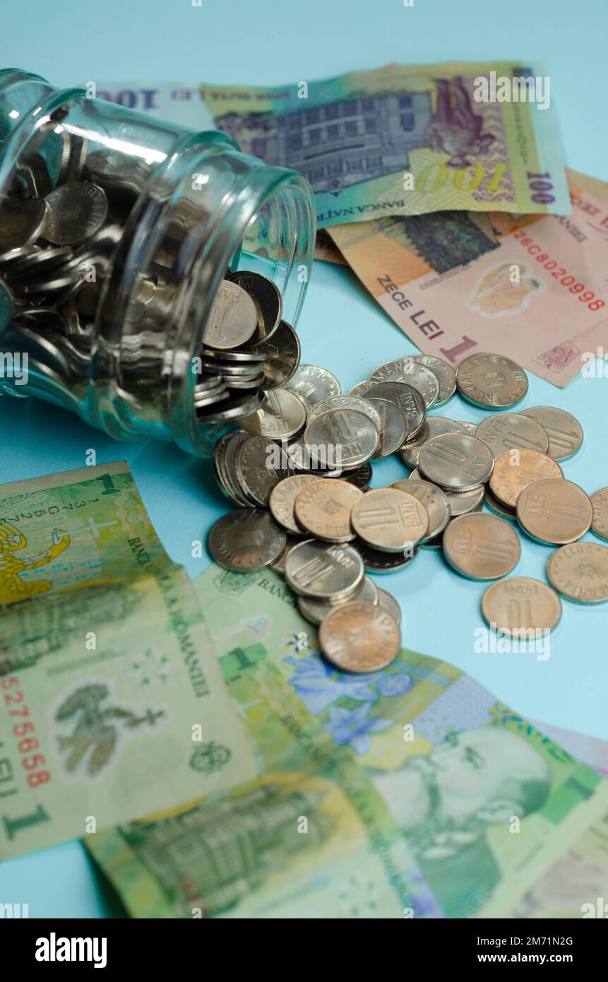 Pots en verre avec pièces de monnaie , isolé - concept d'épargne. Billets de banque roumains, concept économique et financier, hausse des prix, valeur du leu roumain Banque D'Images