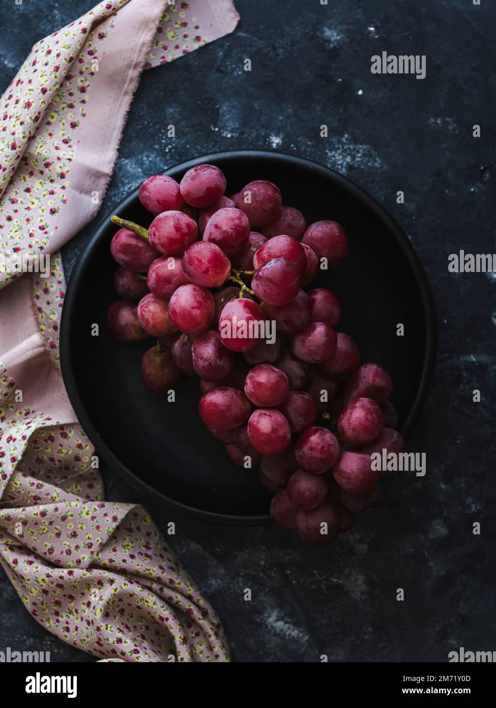 Bouquet de raisins sur une assiette noire Banque D'Images