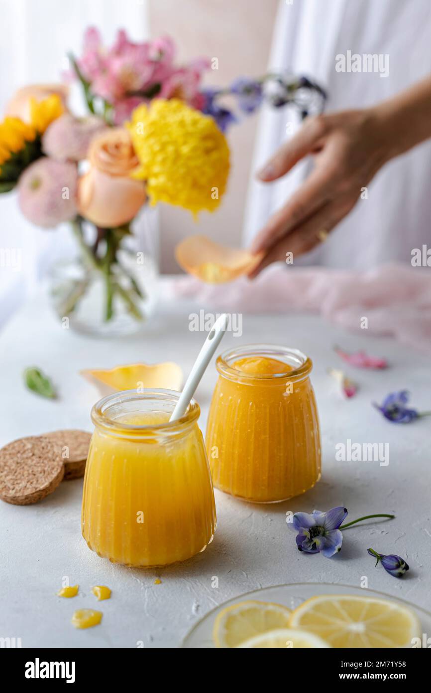 Caillé de citron dans des pots en verre décorés de fleurs printanières et de pastels Banque D'Images