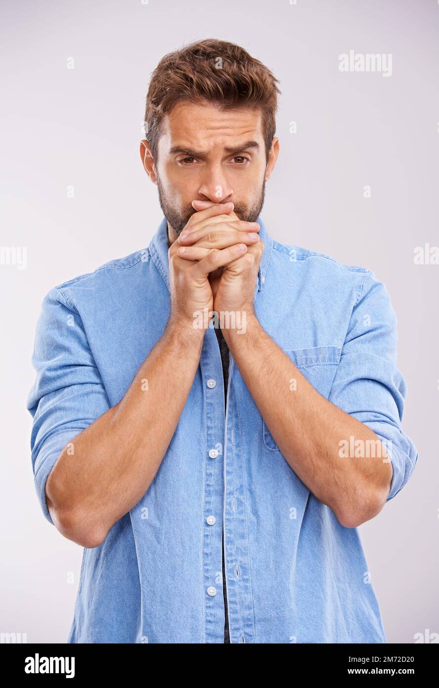 Les nerfs sont en train de s’entaper. Photo studio d'un jeune homme beau et regardant réfléchi sur fond gris. Banque D'Images