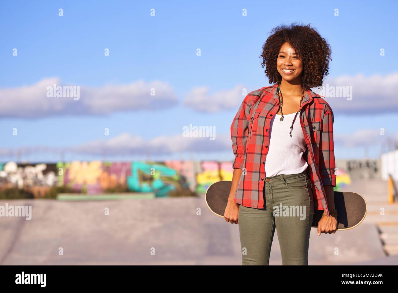 Pourquoi marcher quand vous pouvez skate. Une jeune femme dehors skate dans la ville. Banque D'Images