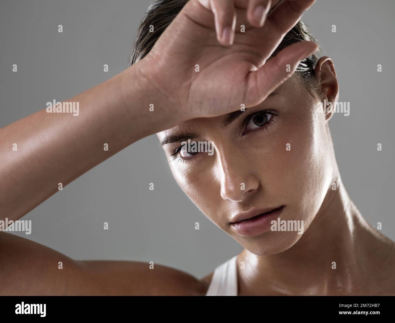 Il est temps de faire une pause. Portrait d'une jeune femme confiante essuyant son front après un entraînement fatigante. Banque D'Images