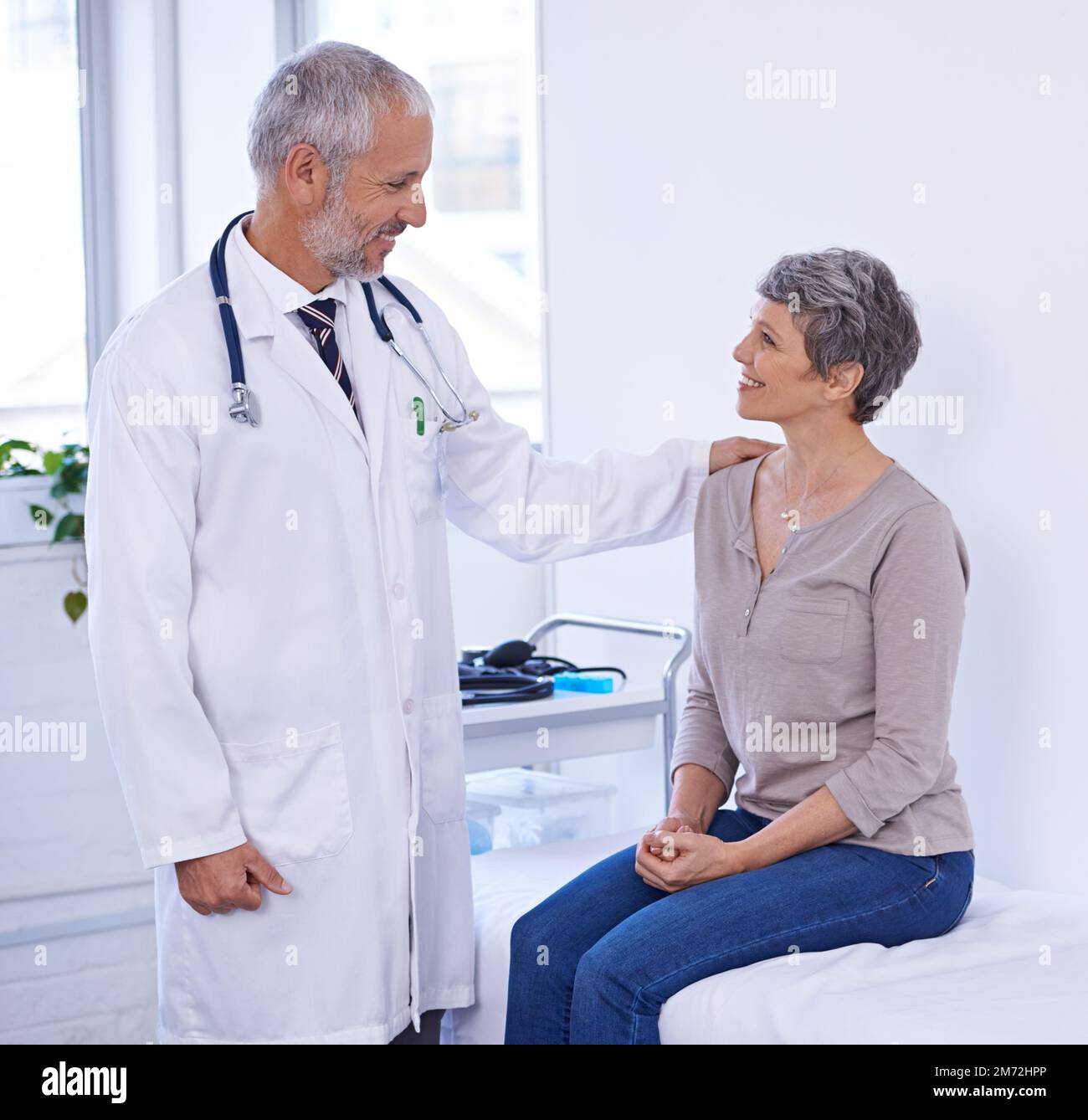 Il a une grande manière au chevet. un médecin rassurant un patient Photo  Stock - Alamy