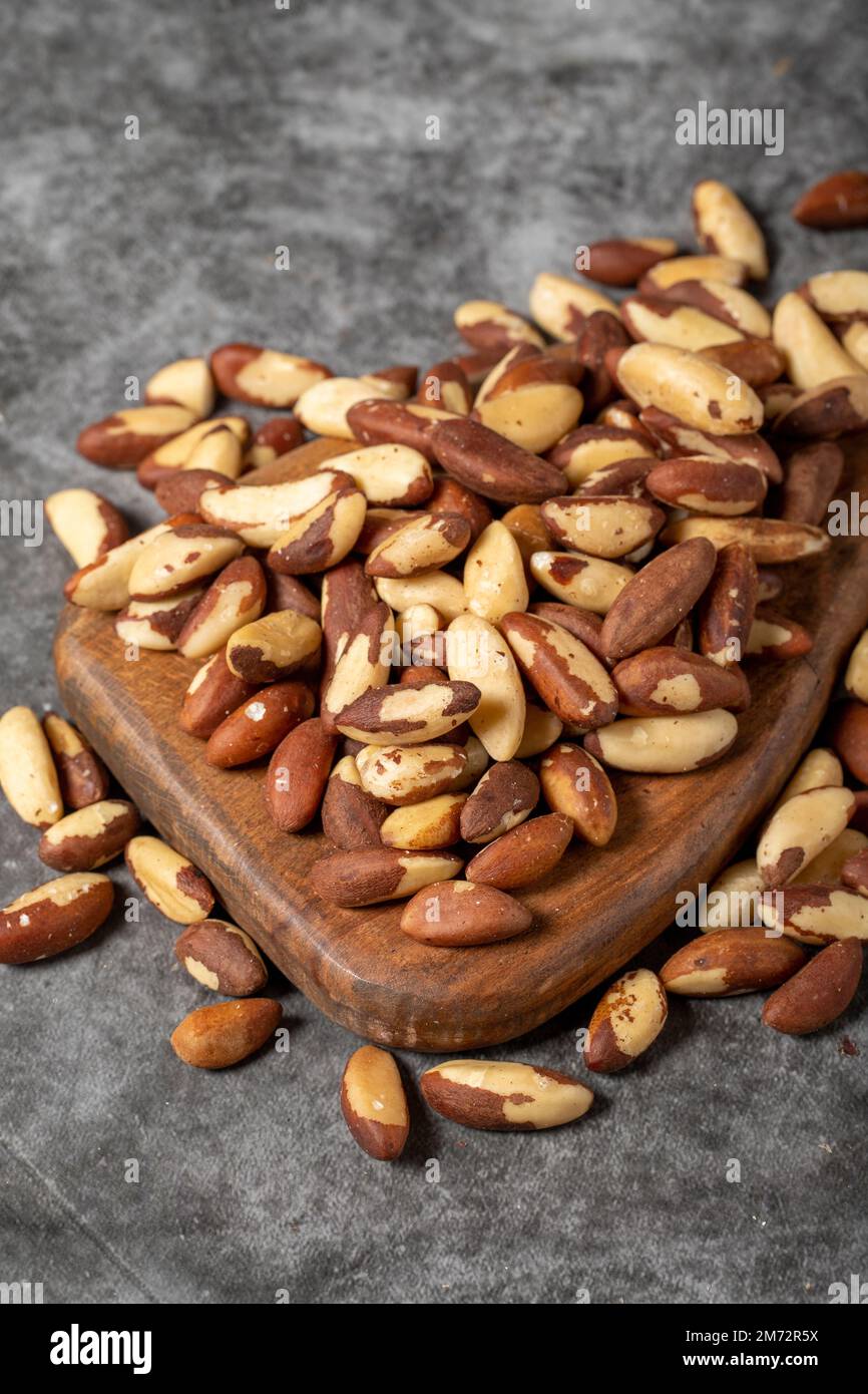 Noix du Brésil sur une planche de service en bois. Pile de noix du Brésil. Prise de vue en studio. gros plan Banque D'Images Noix du Brésil sur une planche de service en bois. Pile de noix du Brésil. Prise de vue en studio. gros plan Banque D'Images