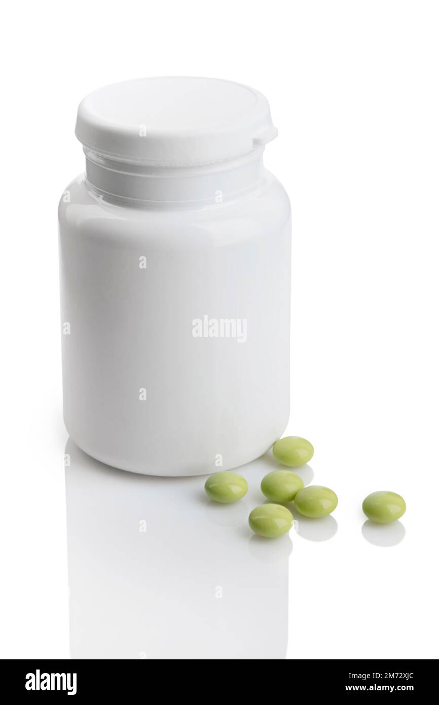 Pilules vertes dispersées autour d'une bouteille en plastique blanc vierge. Isolé sur blanc avec des réflexions Banque D'Images