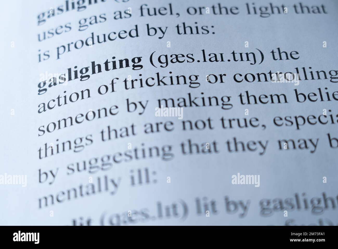 Une maquette d'une page de dictionnaire avec le mot gastlighting avec focalisation sélective Banque D'Images