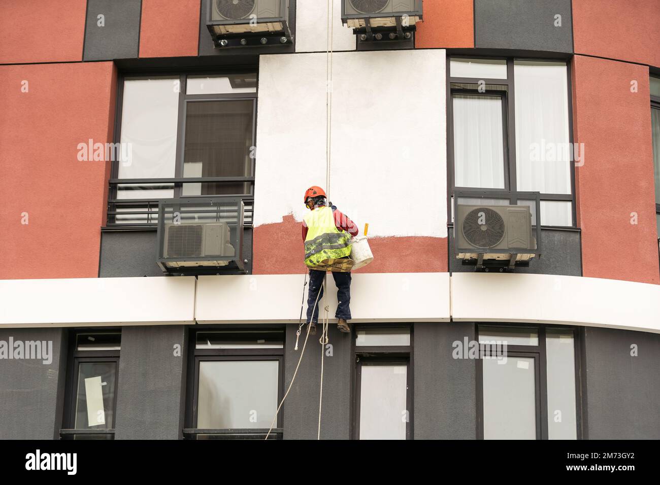 Les peintres-altitude modernisent la façade du bâtiment. Banque D'Images