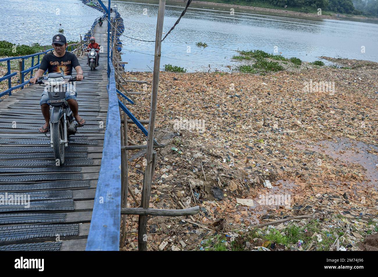 Régence de Bandung Ouest, Indonésie, 7 janvier 2023 - les résidents traversent un pont sous lequel il y a des tas de déchets sur les rives de la rivière Citarum. Banque D'Images