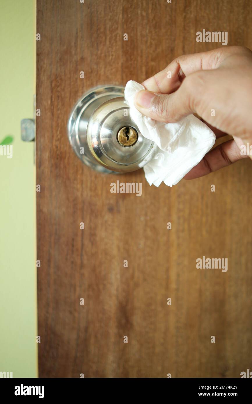 Nettoyage du bouton de la porte avec du papier absorbant Banque D'Images