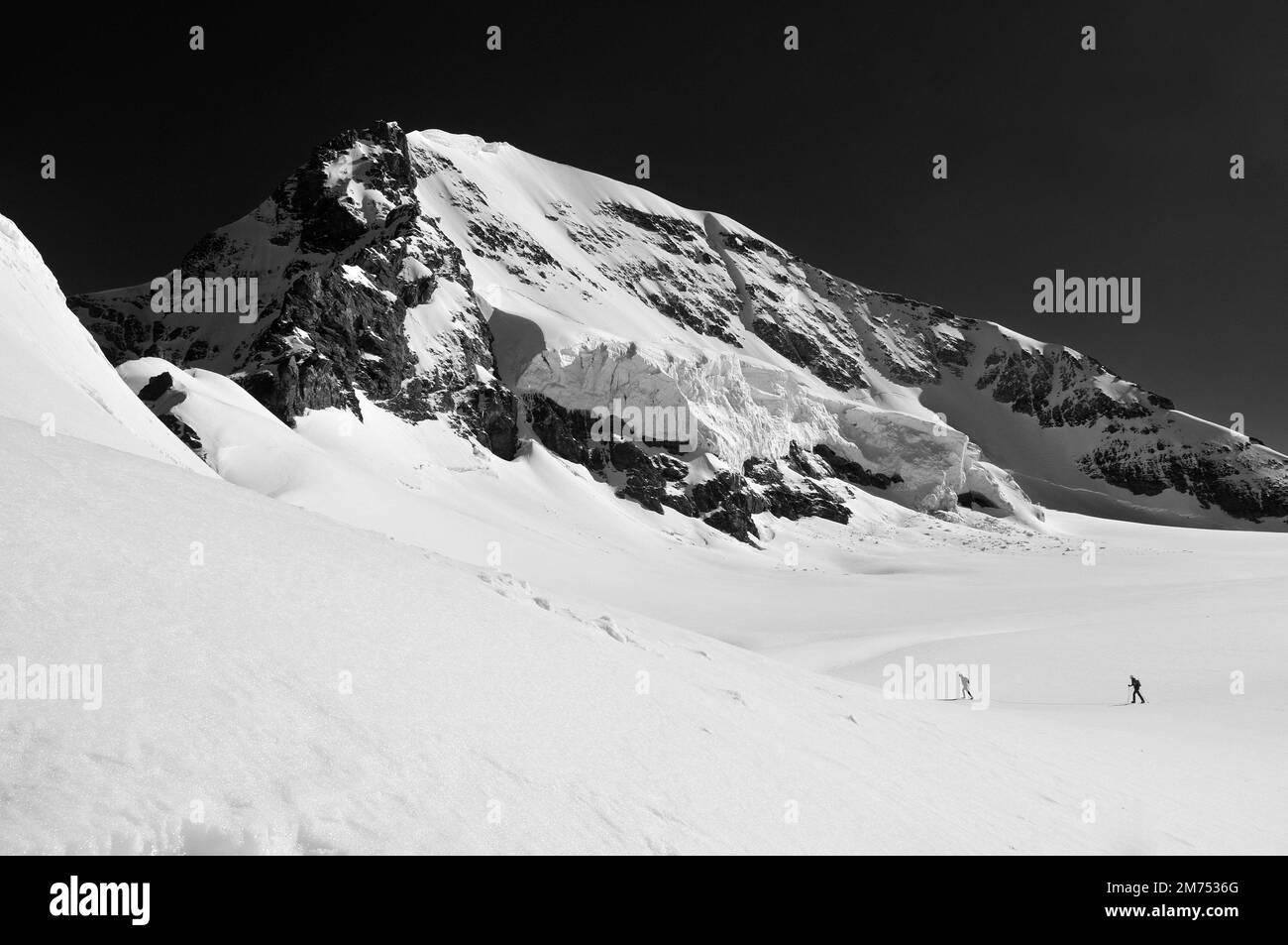 Autour de la Suisse - Jungfraujoch - deux randonneurs ont roulé ensemble sur le glacier, évitant les crevasses. Banque D'Images