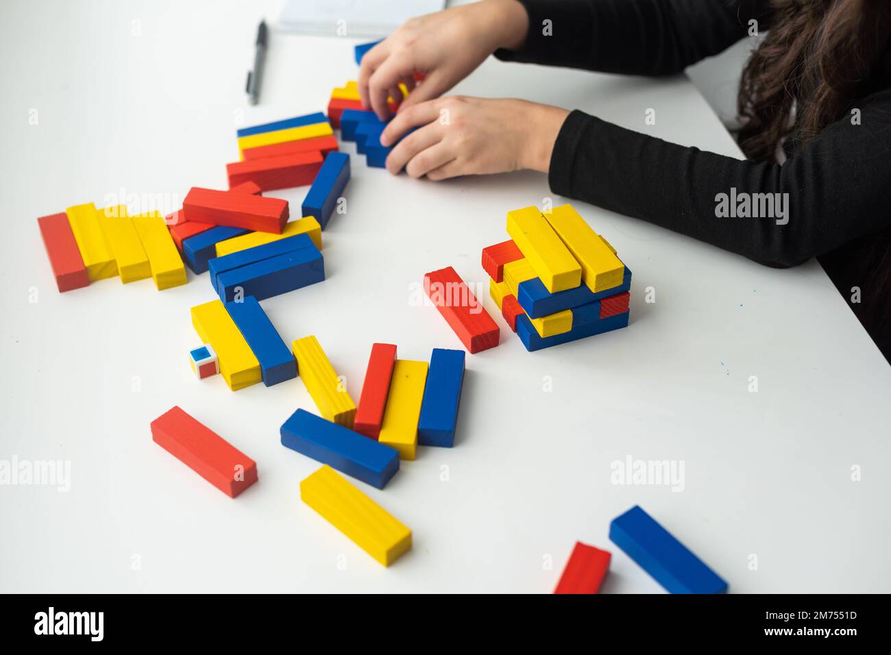 Adorable petite fille excite avec un jeu de blocs en bois Banque D'Images