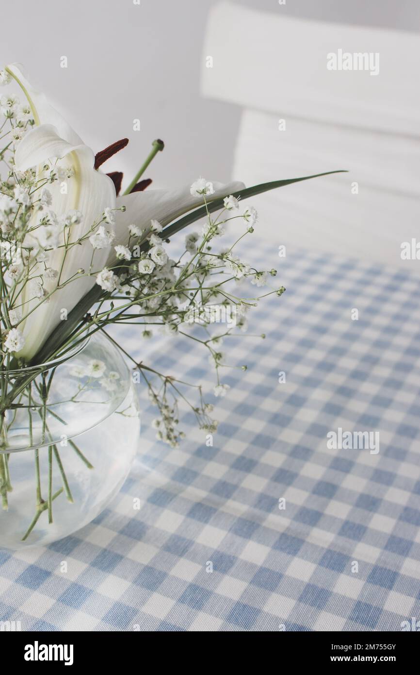 Fleurs blanches dans vase en verre sur table. Décoration de café. Intérieur minimaliste. Concept de pureté. Petites fleurs blanches dans le café. Mariage. Banque D'Images