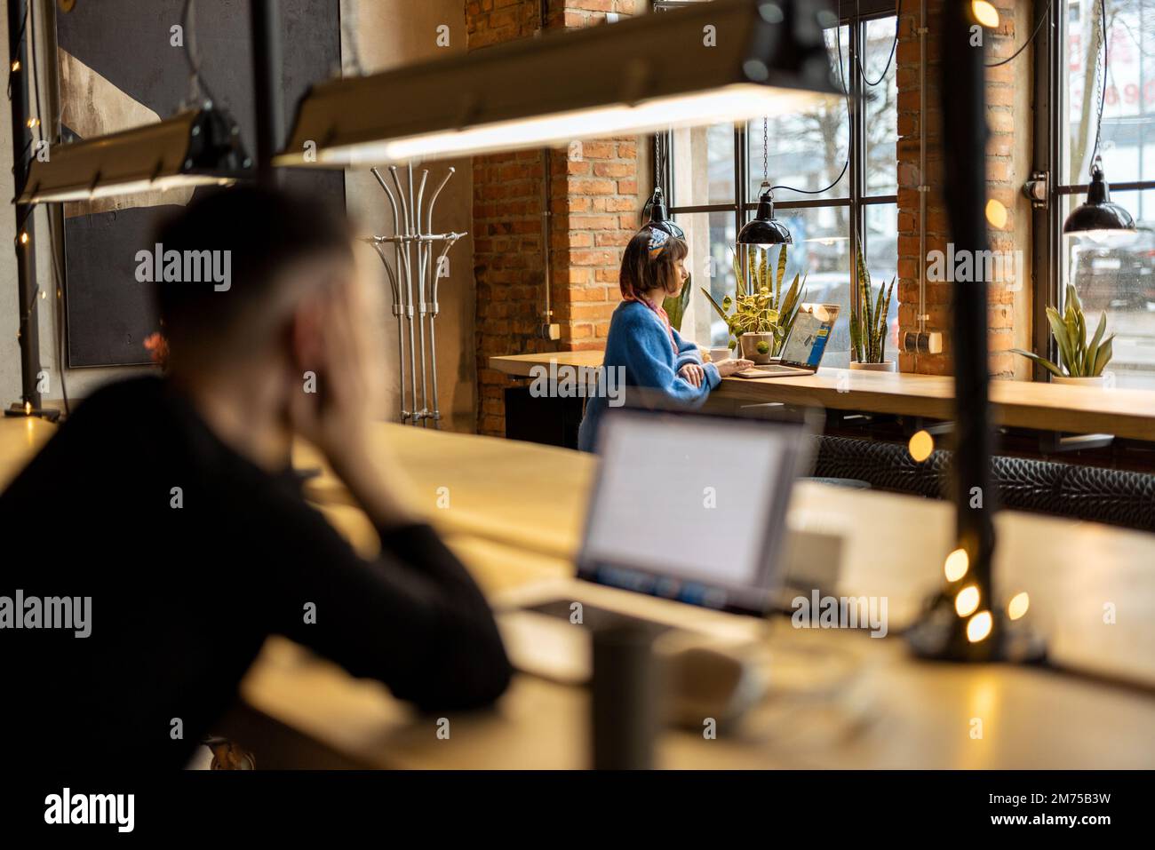 Une femme travaille sur un ordinateur portable au café Banque D'Images