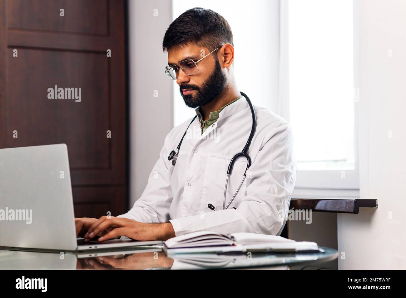 Portrait d'un médecin indien portant un manteau blanc dans le bureau de la clinique Banque D'Images