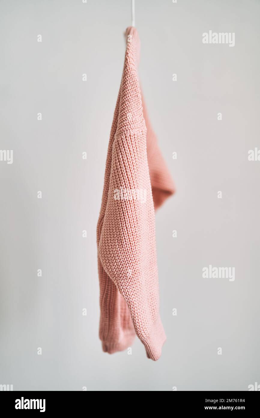 Un pull en laine accroché à un cintre sur fond blanc. Vente de vêtements  chauds Photo Stock - Alamy