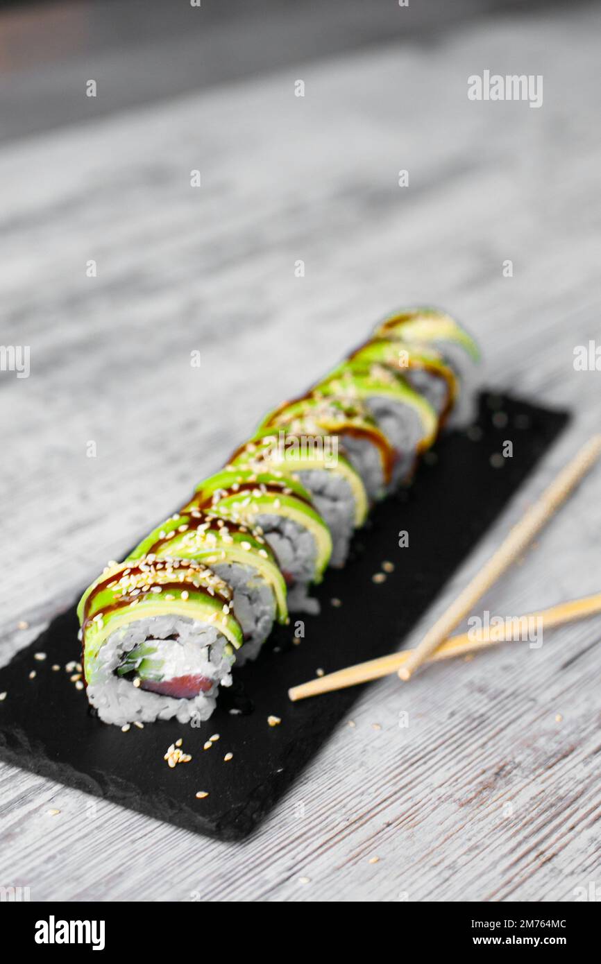 sushi au saumon léger philadelphie avec oignon sur fond blanc de bureau noir avec baguette Banque D'Images