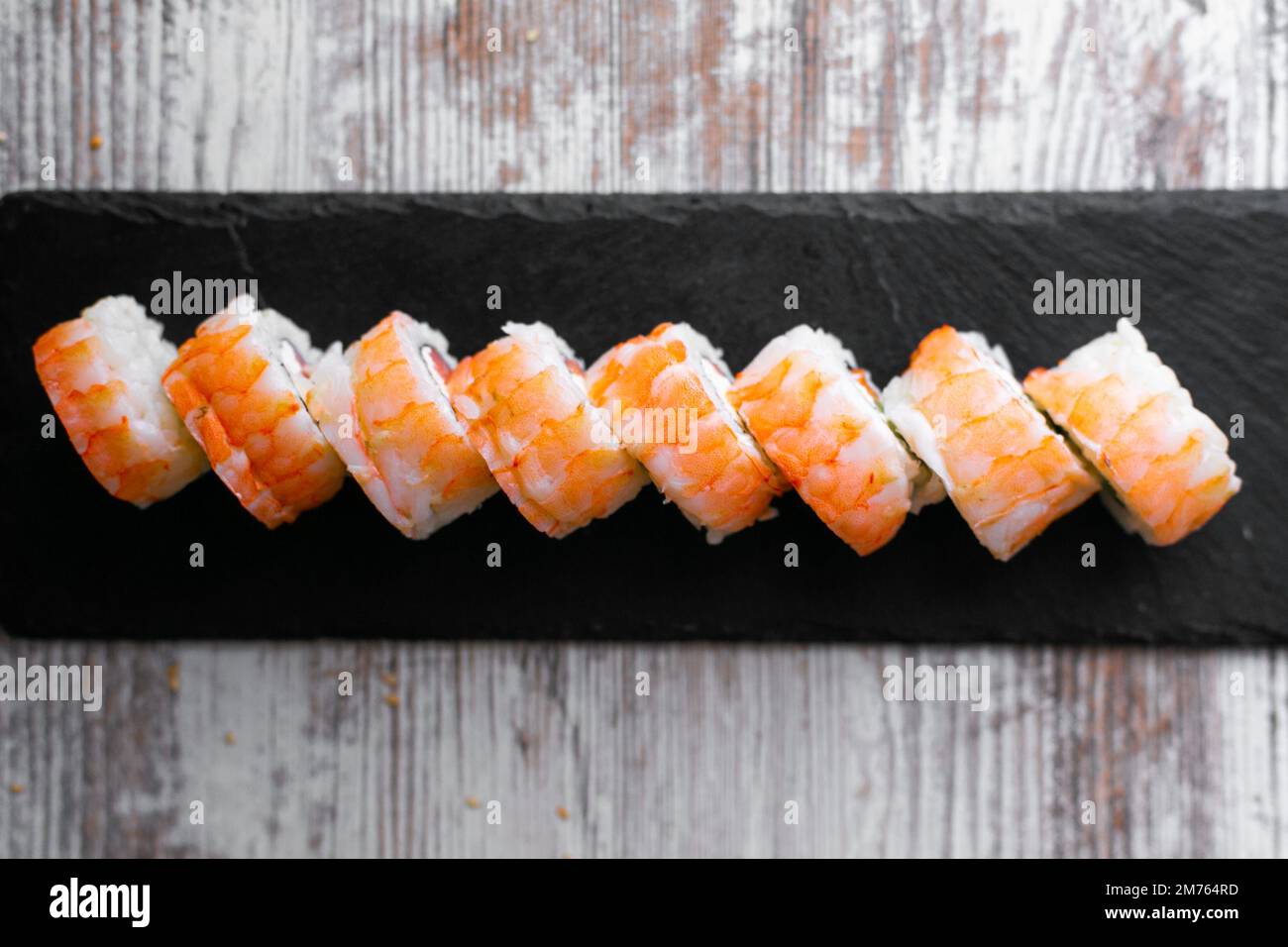 sushi au saumon léger philadelphia sur un bureau noir, fond blanc, vue du dessus Banque D'Images