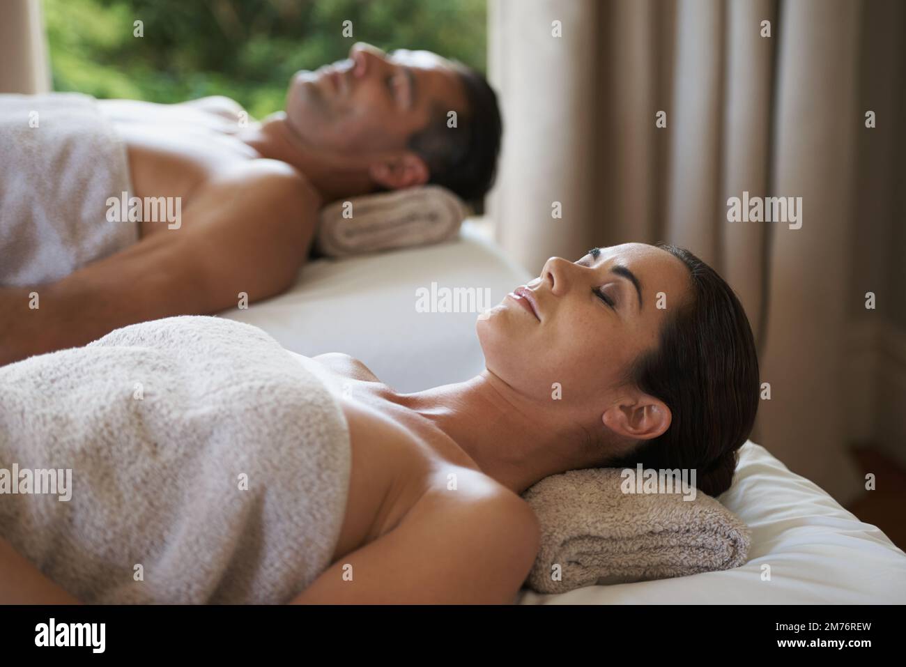 Le plaisir simple de la paix. un couple d'âge mûr se détendant sur leurs tables de massage. Banque D'Images