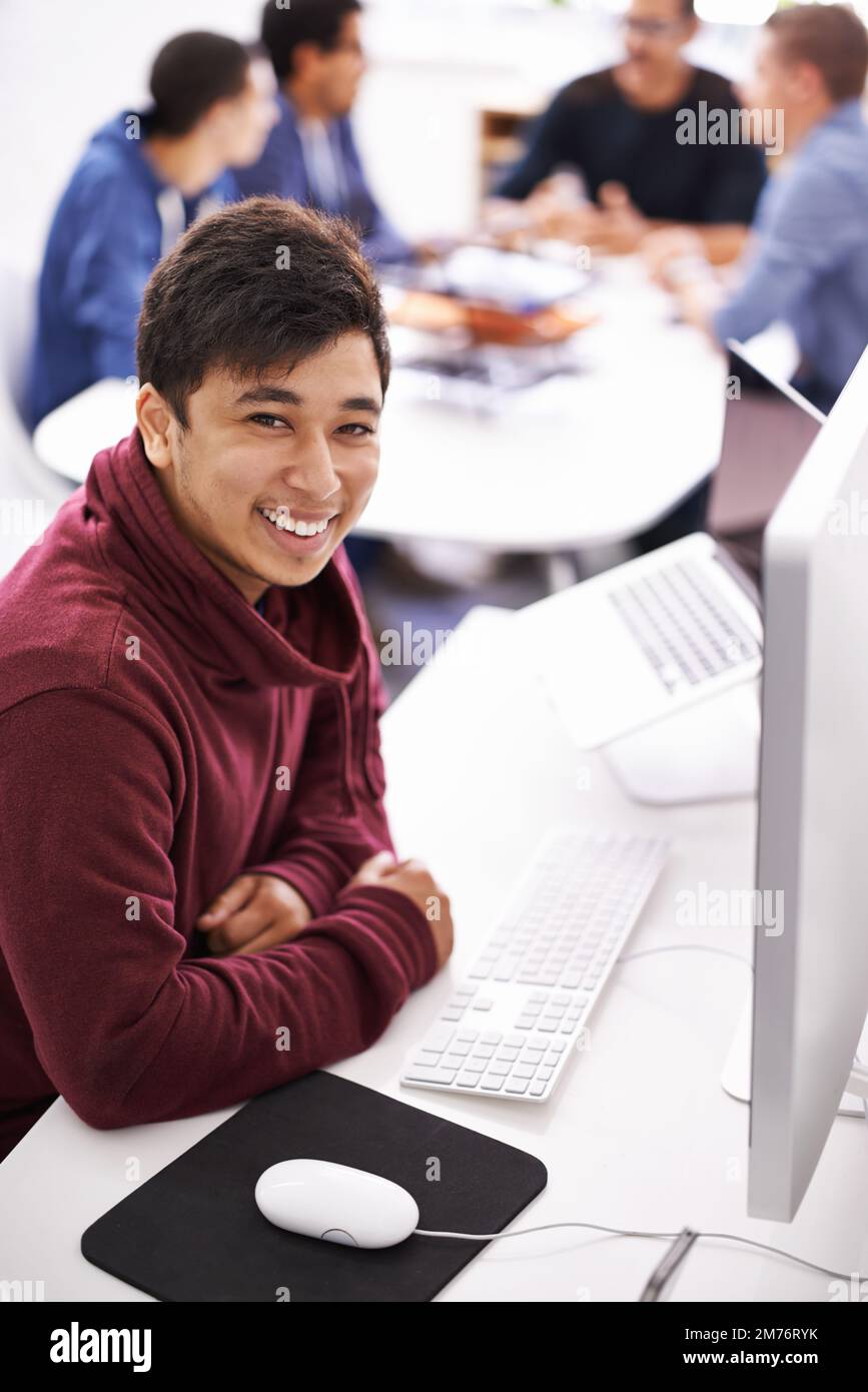 Terminé, avec du temps libre. un beau jeune homme qui travaille sur son ordinateur portable dans un bureau. Banque D'Images